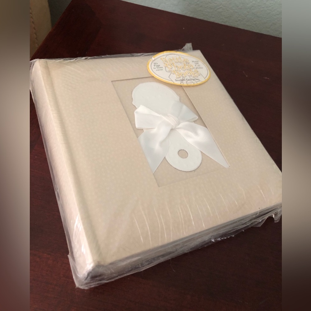 beige baby photo album features a front window for a personalized picture